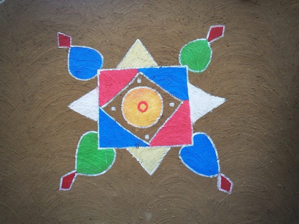 Vibrant geometric rangoli design on brown textured surface, showcasing Indian folk art and cultural heritage.